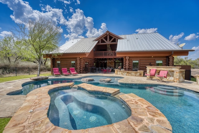 view of pool featuring fence, outdoor dry bar, a pool with connected hot tub, and a patio