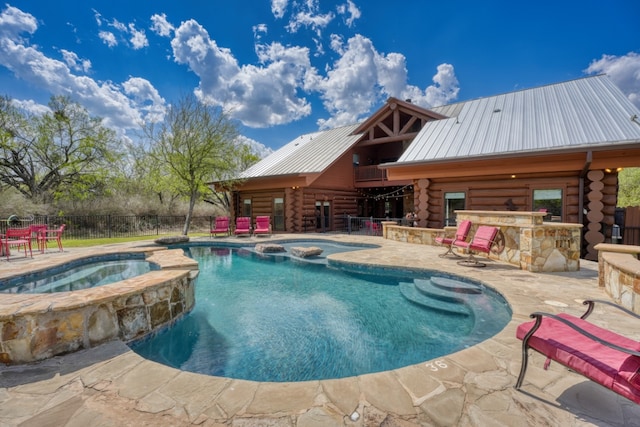 view of pool featuring fence, a patio area, outdoor dry bar, and a pool with connected hot tub