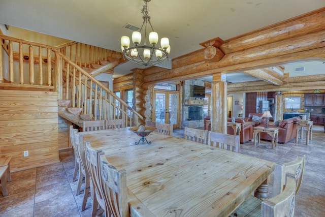 dining room with rustic walls, stairway, visible vents, french doors, and a chandelier