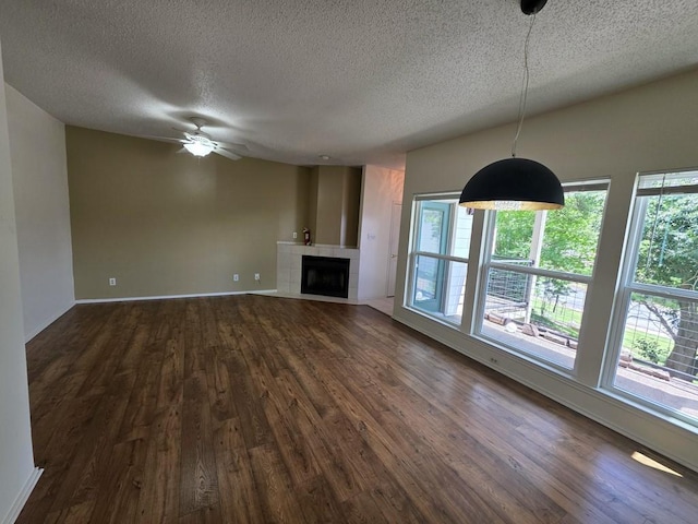 6600 Valleyside Rd Unit 24, Austin, TX 78731 - unfurnished living room with a textured ceiling, dark wood-type flooring, healthy amount of natural light, and a ceiling fan