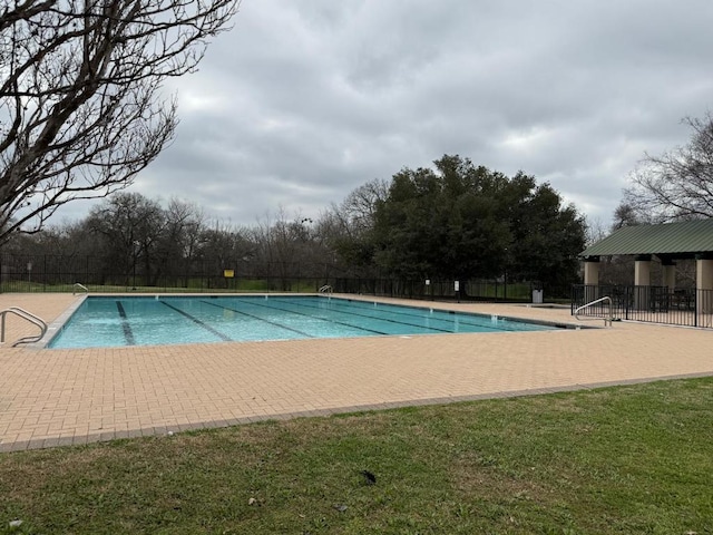 community pool with fence and a patio