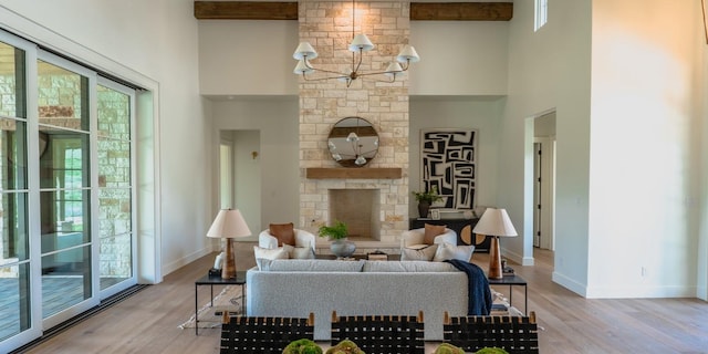 living area with light wood-style flooring, a towering ceiling, and baseboards