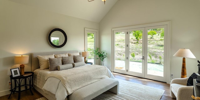 bedroom with wood finished floors, high vaulted ceiling, and access to exterior