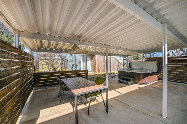 view of patio / terrace featuring a ceiling fan, a hot tub, a fenced backyard, and outdoor dining space