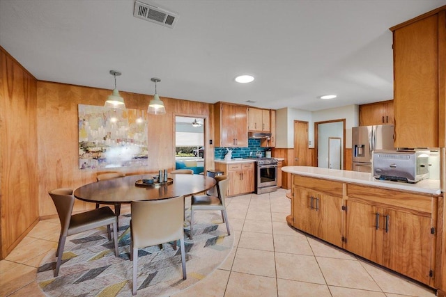 kitchen with decorative backsplash, light tile patterned floors, light countertops, appliances with stainless steel finishes, and visible vents