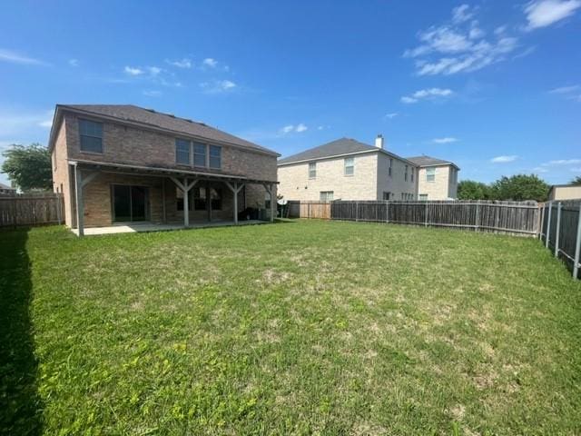 back of house featuring a lawn, a fenced backyard, and a patio