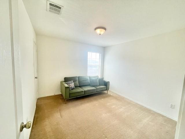 unfurnished room featuring baseboards, visible vents, and light colored carpet