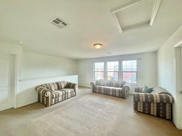 living area featuring attic access, visible vents, and carpet floors