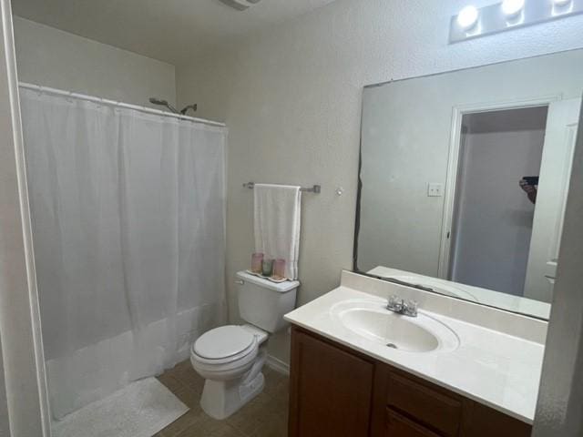full bath with tile patterned floors, toilet, vanity, and shower / bath combination with curtain