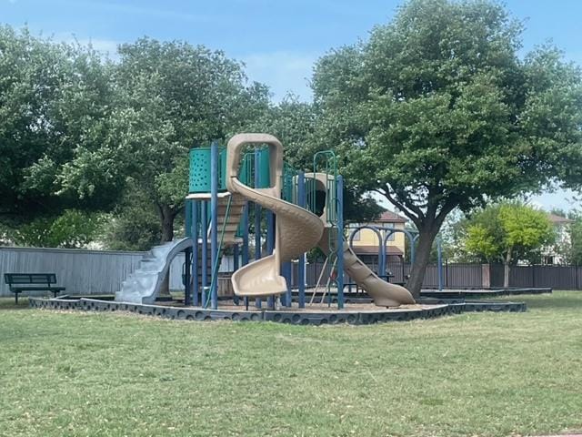 community jungle gym featuring a yard and fence