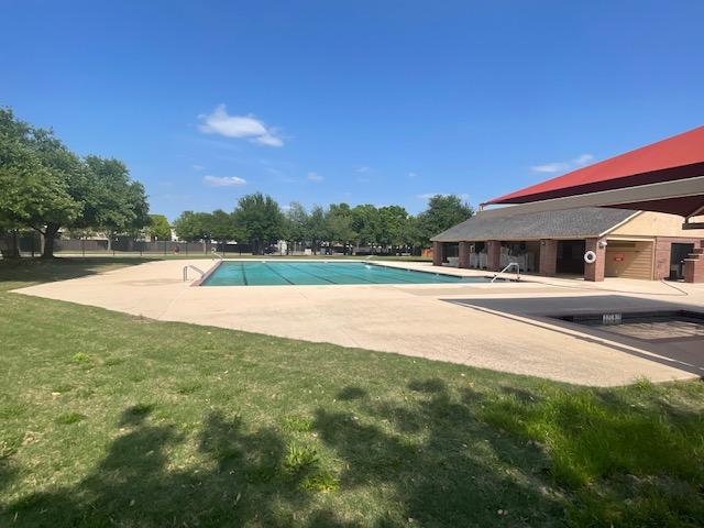 pool with a yard and a patio
