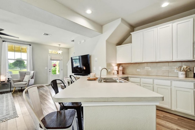 184 Martha Ln, Kyle, TX 78640 - kitchen with a sink, light countertops, a kitchen breakfast bar, a peninsula, and white cabinetry
