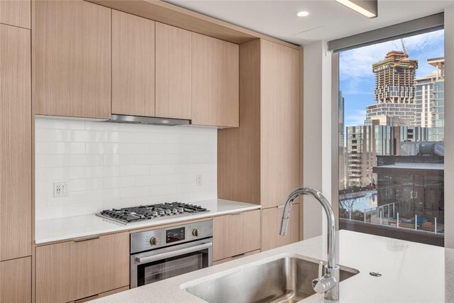 44 E Ave Unit 3107, Austin, TX 78701 - kitchen with appliances with stainless steel finishes, backsplash, a sink, and light countertops