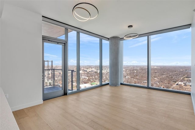 44 E Ave Unit 3107, Austin, TX 78701 - unfurnished room featuring floor to ceiling windows, wood finished floors, and baseboards