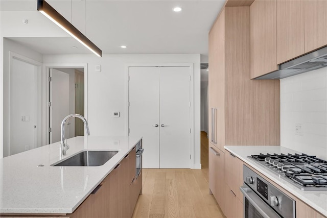 44 E Ave Unit 3107, Austin, TX 78701 - kitchen featuring modern cabinets, a sink, stainless steel appliances, light wood-style flooring, and light brown cabinets
