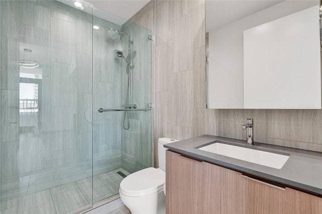 44 E Ave Unit 3107, Austin, TX 78701 - bathroom featuring toilet, tile walls, a shower stall, and vanity