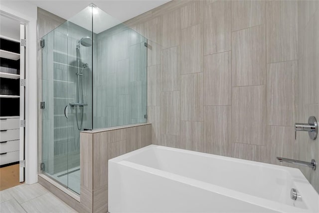 44 E Ave Unit 3107, Austin, TX 78701 - bathroom with a garden tub, a shower stall, and tile patterned floors