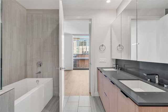 44 E Ave Unit 3107, Austin, TX 78701 - bathroom with double vanity, tub / shower combination, baseboards, and recessed lighting