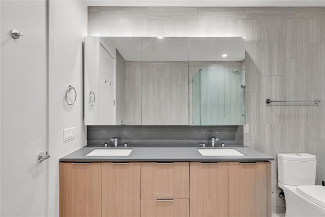 44 E Ave Unit 3107, Austin, TX 78701 - bathroom featuring double vanity, toilet, a shower with shower door, and tile walls