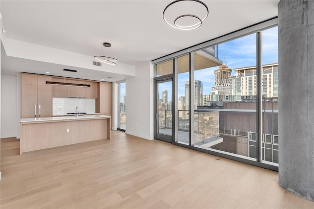 44 E Ave Unit 3107, Austin, TX 78701 - unfurnished living room with a view of skyline, light wood-style floors, plenty of natural light, and a wall of windows