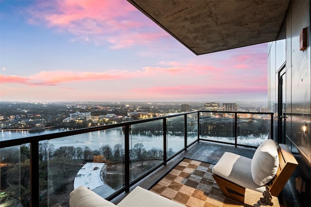 balcony with a water view and a view of city