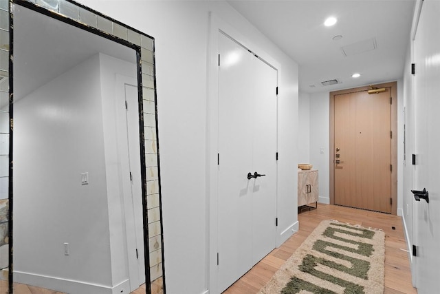 hall with recessed lighting, visible vents, light wood finished floors, and baseboards