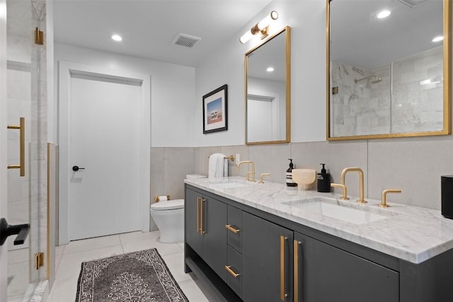 full bath with visible vents, a sink, a shower stall, and toilet