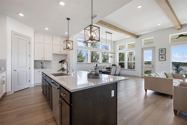 298 Smoke Tree Cir, Dripping Springs, TX 78620 - kitchen featuring a chandelier, beam ceiling, wood finished floors, light countertops, and open floor plan