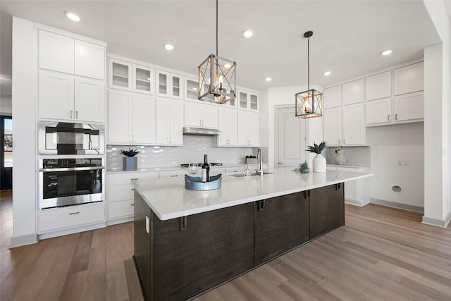 298 Smoke Tree Cir, Dripping Springs, TX 78620 - kitchen featuring stainless steel oven, backsplash, white cabinetry, wood finished floors, and recessed lighting