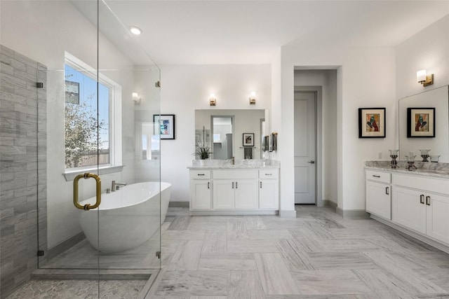 298 Smoke Tree Cir, Dripping Springs, TX 78620 - bathroom featuring two vanities, a soaking tub, and a shower stall