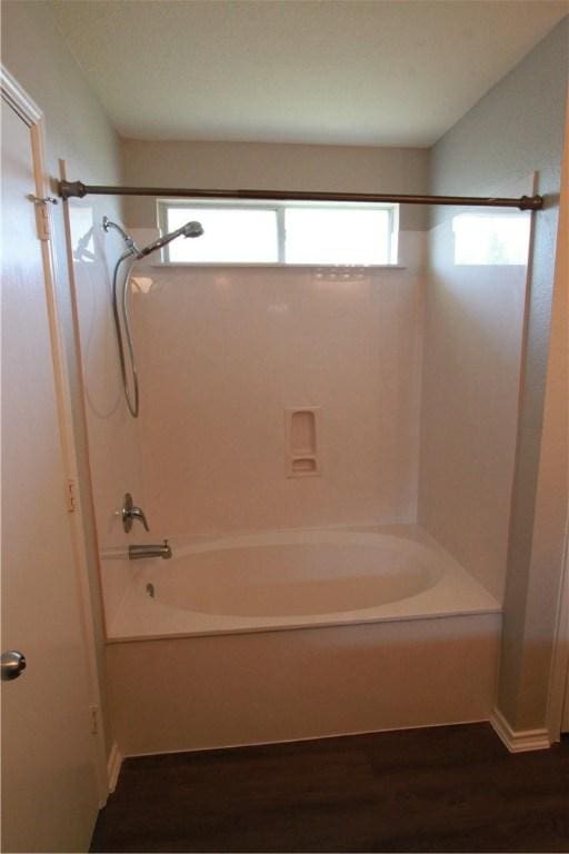 122 Bayliss St, Hutto, TX 78634 - bathroom with wood finished floors and shower / bath combination