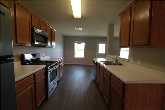 122 Bayliss St, Hutto, TX 78634 - kitchen featuring a sink, light countertops, dark wood finished floors, baseboards, and appliances with stainless steel finishes