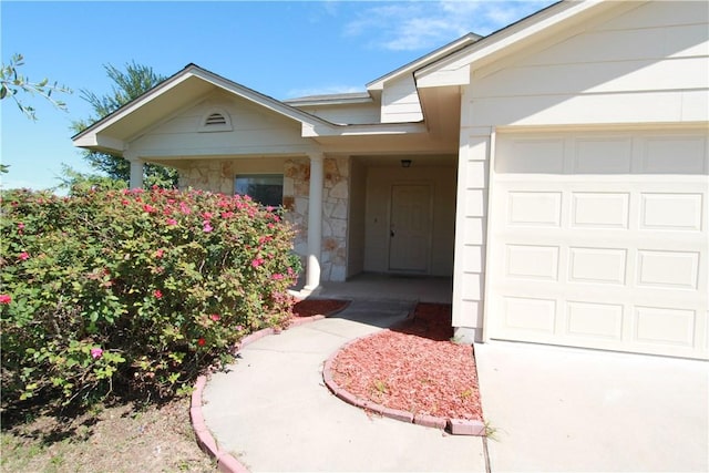 122 Bayliss St, Hutto, TX 78634 - view of exterior entry with a garage and stone siding