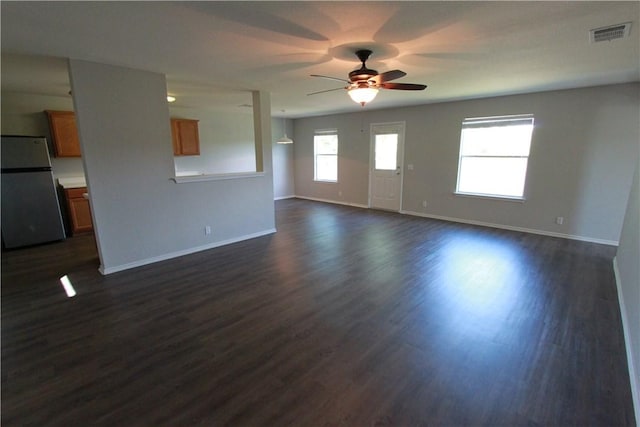 122 Bayliss St, Hutto, TX 78634 - unfurnished living room with dark wood finished floors, visible vents, baseboards, and ceiling fan