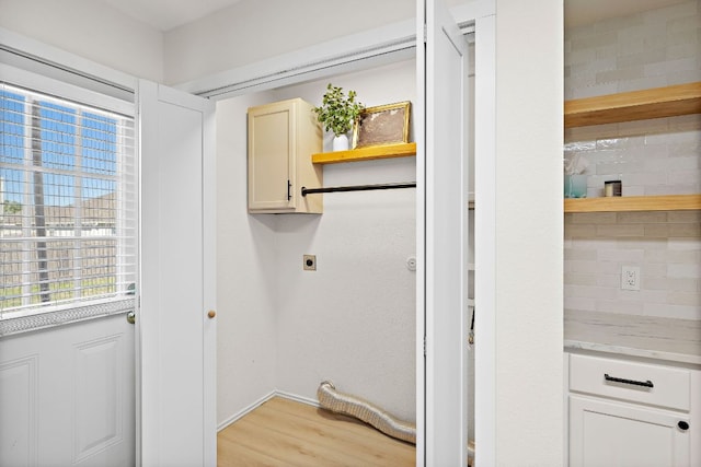 laundry area featuring cabinet space, light wood-style floors, baseboards, and hookup for an electric dryer