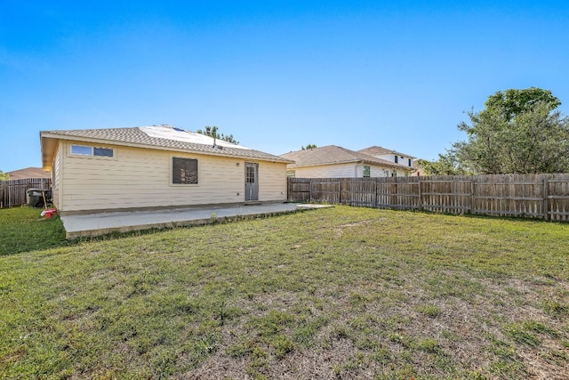 back of property featuring a fenced backyard, a patio area, and a lawn