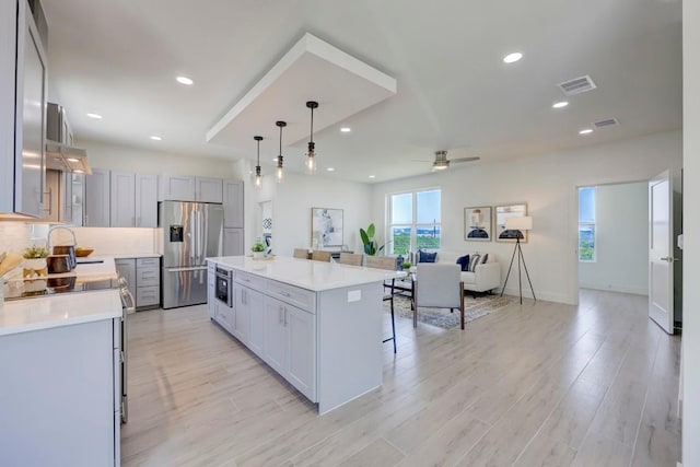 4300 Mansfield Dam Ct Unit 1231, Austin, TX 78734 - kitchen with stainless steel refrigerator with ice dispenser, light countertops, a kitchen island, ceiling fan, and a breakfast bar