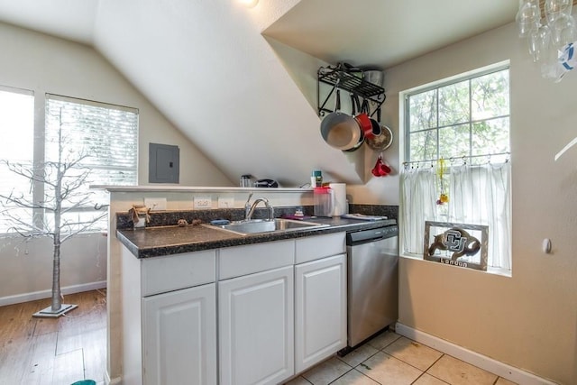 kitchen with white cabinets, a peninsula, a sink, lofted ceiling, and dishwasher