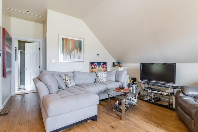 living area with vaulted ceiling, wood finished floors, and visible vents