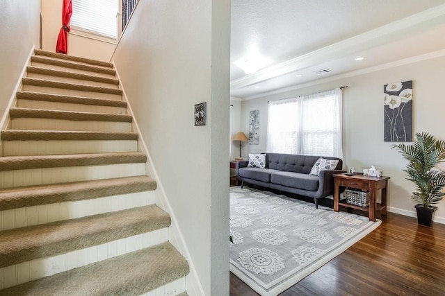 staircase with visible vents, baseboards, recessed lighting, wood finished floors, and crown molding