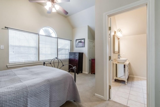 bedroom with connected bathroom, a ceiling fan, a sink, lofted ceiling, and baseboards
