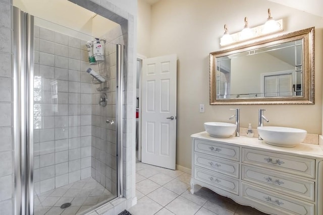 full bath featuring tile patterned floors, a sink, double vanity, and a stall shower