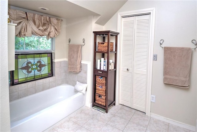 full bath featuring a garden tub, a closet, and tile patterned flooring