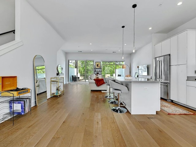 505 Tillery St Unit 6, Austin, TX 78702 - kitchen with high quality fridge, modern cabinets, white cabinetry, light wood finished floors, and recessed lighting