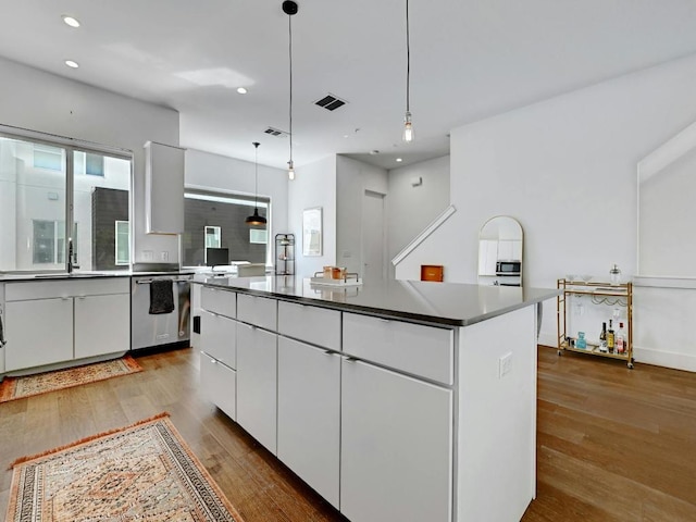 505 Tillery St Unit 6, Austin, TX 78702 - kitchen featuring stainless steel appliances, a center island, wood finished floors, recessed lighting, and white cabinets