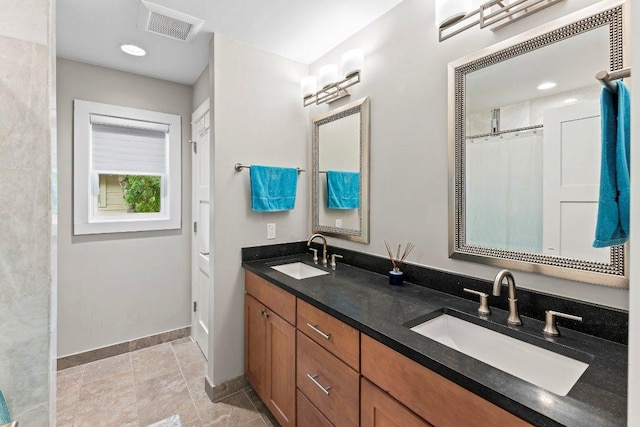 full bathroom with baseboards, a sink, visible vents, and double vanity