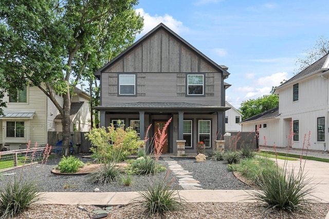 rear view of house with covered porch and fence
