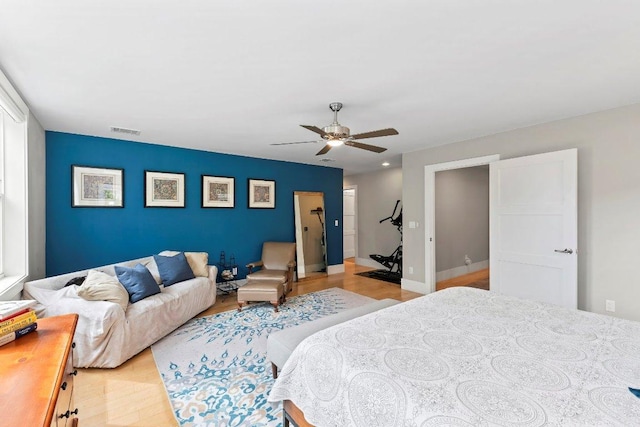 bedroom with ceiling fan, baseboards, wood finished floors, and visible vents