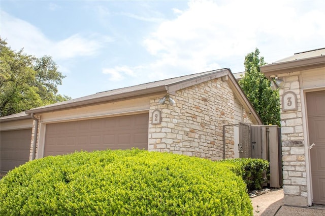 2201 Lakeway Blvd Unit 2, Lakeway, TX 78734 - view of property exterior featuring stone siding and an attached garage