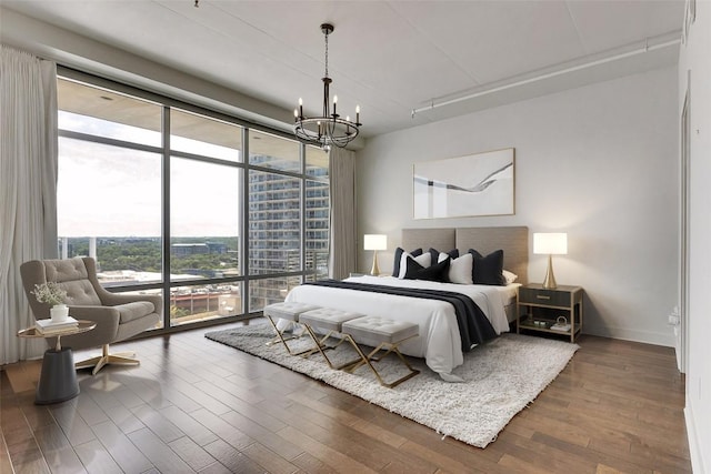 800 W 5th St Unit 1008, Austin, TX 78703 - bedroom with expansive windows, a chandelier, wood finished floors, baseboards, and access to exterior